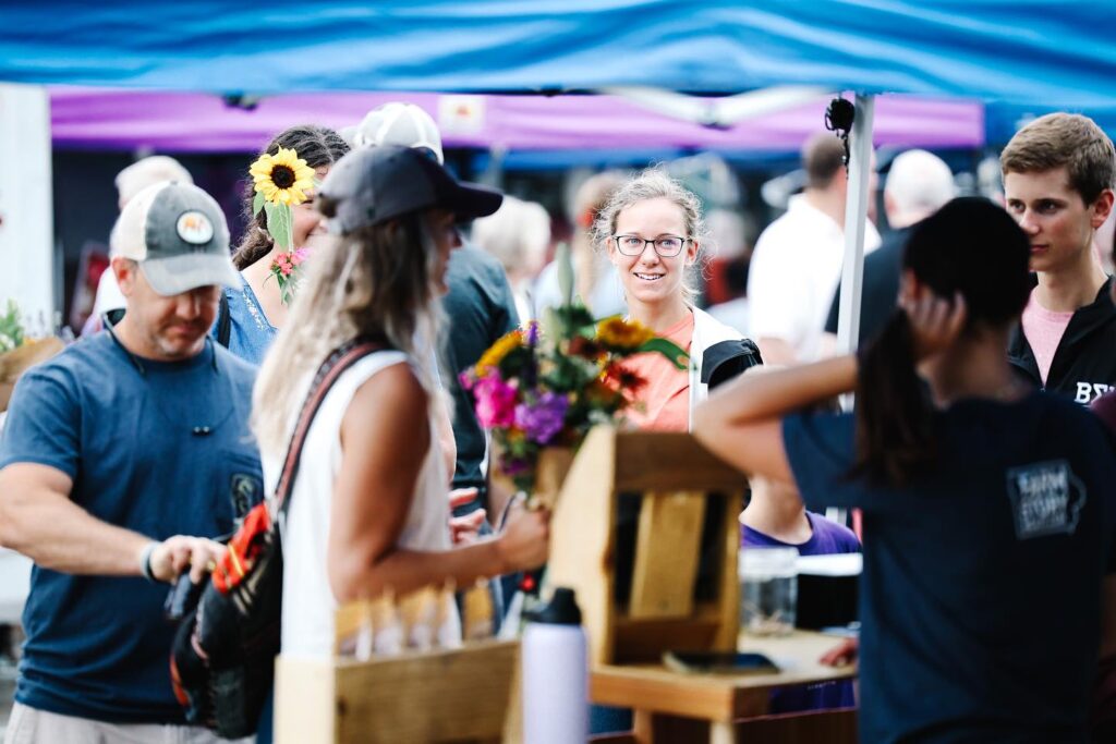 Group of people at a Farmers Market stand