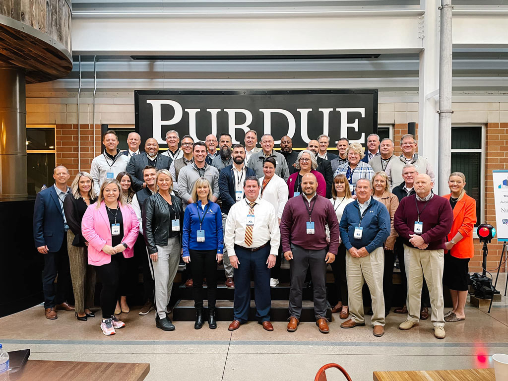 Group stands in front of Purdue Sign at 2023 InterCity visit event