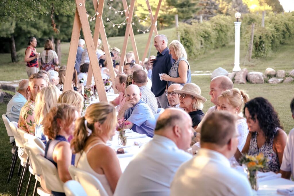 Members sitting at a long table during a picnic event