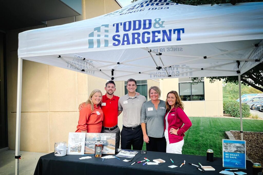 Team poses at booth for Todd and Sargent company