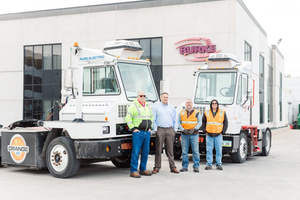 Burke Corporation workers in front of electric vehicles